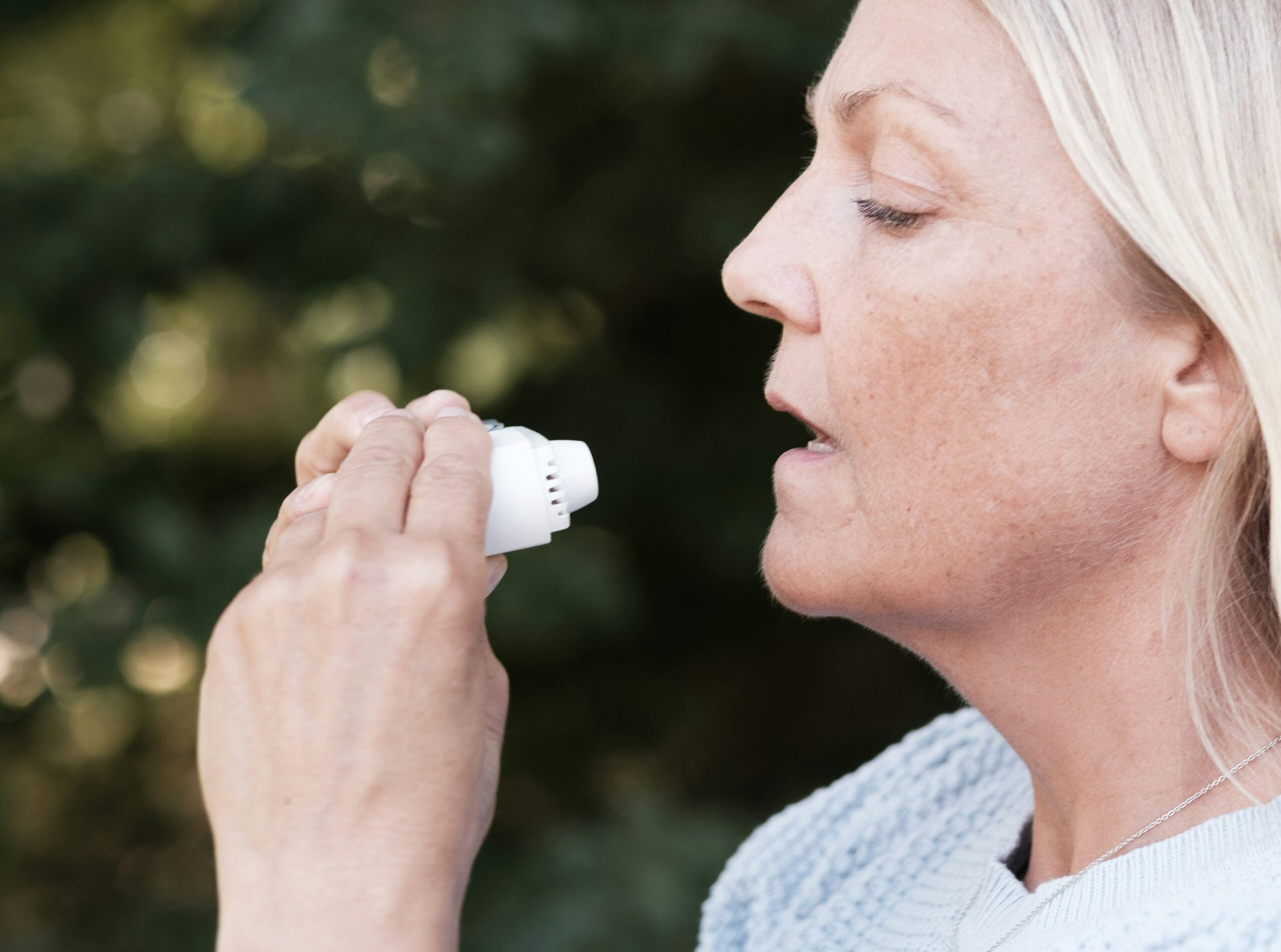 A person wearing a wearable lung monitoring device at home while doing yoga