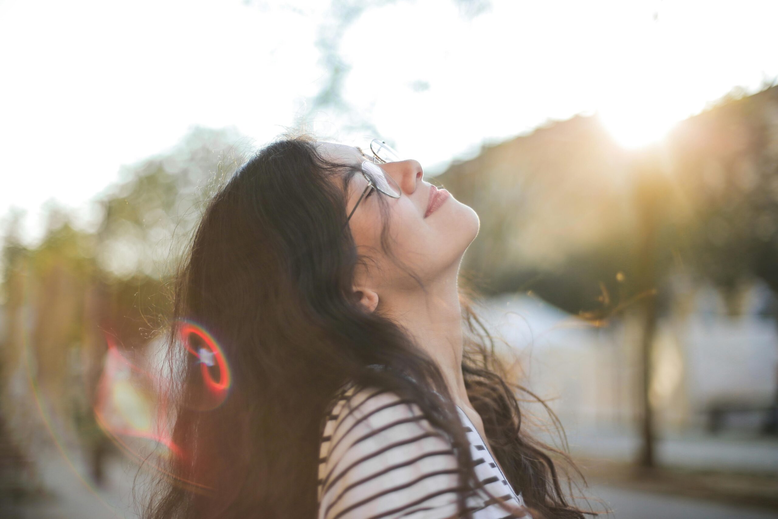 Photo of smiling woman standing outdoors after completing a morning session of mindful breathing exercises.